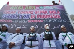 Pengunjuk rasa berdiri saat berdemonstrasi di Jakarta, Senin, 20 Maret 2023. (Foto: AP)