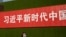 一名女子从北京街头张贴的一条宣传习近平新时代的标语下走过。（2019年9月27日）