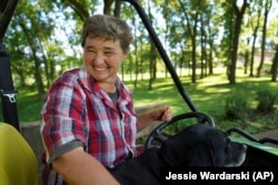 Sister Elaine Fischer rides through the Mount St. Scholastica Benedictine monastery grounds with Sophie, the community's dog, on Wednesday, July 17, 2024, in Atchison, Kansas. (AP Photo/Jessie Wardarski)