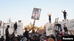 Para pengunjuk rasa bentrok dengan anggota pasukan keamanan ketika mereka berkumpul di dekat kedutaan Swedia di Bagdad beberapa jam setelah kedutaan itu diserbu dan dibakar menjelang pembakaran Al-Quran di Stockholm, di Bagdad, Irak, 20 Juli 2023. (Foto: REUTERS/Ahmed Saad)