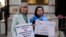 FILE - Helena Kennedy, left, and Rahima Mahmut hold placards as activists protest at the British Foreign Office in London, Feb. 13, 2023. They were demanding a meeting with the foreign secretary to highlight concerns for compatriots in China's Xinjiang Uyghur Autonomous Region.