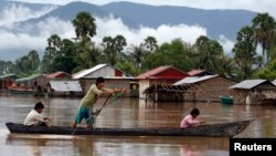 រូបឯកសារ៖ អ្នក​ស្រុក​អុំ​ទូក​ឆ្លង​កាត់​ភូមិ​ដែល​រង​គ្រោះ​ដោយ​ទឹក​ជំនន់​ក្នុង​ខេត្ត​កំពត ប្រទេស​កម្ពុជា កាល​ពី​ថ្ងៃ​ទី៨ ខែ​កញ្ញា ឆ្នាំ​២០០៩។