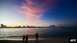 FILE - People walk along a beach at Vilimalé island in the the Maldives on Nov. 15, 2023. 