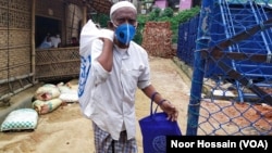 A Rohingya man walks out of a World Food Program-run shop at a refugee camp in Cox’s Bazar, Bangladesh.