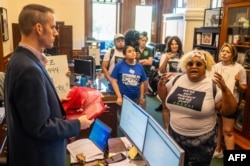 Aktivis mengunjungi kantor anggota parlemen Texas untuk mengantarkan surat dari orang-orang yang dipenjara, meminta perubahan dalam sistem penjara, di gedung Texas State Capitol di Austin, Texas, pada 18 Juli 2023. (Sergio FLORES / AFP)