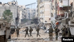 Militer Israel berpatroli di dekat kompleks Rumah Sakit Al Shifa di Kota Gaza, di utara Jalur Gaza, 22 November 2023. (REUTERS/Ronen Zvulun)