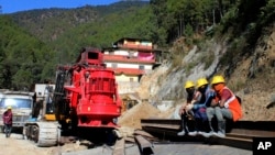 Rescuers rest at the site of an under-construction road tunnel that collapsed in Silkyara in the northern Indian state of Uttarakhand, Nov. 24, 2023. 