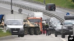 An APC and road police officers stand on the highway at the entrance to Moscow, Russia, June 24, 2023. 
