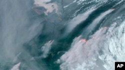 Foto satelit yang diambil pada 6 Juni 2023 menunjukkan asap kebakaran hutan yang melanda sejumlah provinsi di Kanada seperti Quebec (kanan) dan Ontario (kiri) bergerak ke arah selatan. (Foto: CIRA/NOAA via AP)