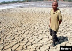 Seorang warga desa berjalan di atas tanah kering di Purwodadi di Jawa Tengah 28 Agustus 2002. (Foto: Reuters)