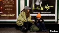 People sit in a metro station to shelter from an air raid, during Russia's attack on Ukraine, in Kyiv, Ukraine, Nov. 11, 2023.