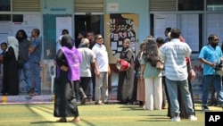 Maldivians stand in a queue to cast their votes in Male, Maldives, Sept. 30, 2023.
