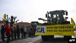 Warga lokal di sebuah desa di wilayah Villeneuve-sur-Lot menyuarakan dukungan terhadap petani Prancis yang bergerak menuju pasar Rungis dengan menggunakan traktor pada 29 Januari 2024. (Foto: AFP/Christophe Archambault)