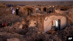 FILE - Afghan men search for victims after an earthquake in Zenda Jan district in Herat province, of western Afghanistan, on Oct. 8, 2023.