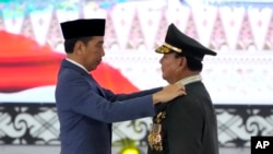 ແຟ້ມພາບ - ລັດຖະມົນຕີປ້ອງກັນປະເທດຂອງອິນໂດເນເຊຍ ທ່ານ ປຣາໂບໂວ ຊູບຽນໂຕ, ຂວາ, ຮັບເອົາອິນທະນູບ່ານາຍພົນ 4 ດາວ ຈາກປະທານາທິບໍດີ ໂຈໂກ ວິໂດໂດ ລະຫວ່າງພິທີ ຢູ່ສຳນັກງານໃຫຍ່ກອງທັບ ໃນນະຄອນຫຼວງຈາກາຕາ, ອິນໂດເນເຊຍ, ວັນທີ 28 ກຸມພາ 2024.