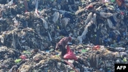 FILE — A man searches for food among garbage in Tegucigalpa, Honduras, Nov. 30, 2023. As many as 783 million people around the world suffer from hunger, Action Against Hunger, an international organization, said on Tuesday. 