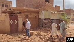 People check a damaged house in southern Khartoum on June 12, 2023, as deadly shelling and gunfire resumed after the end of a 24-hour cease-fire in Sudan.