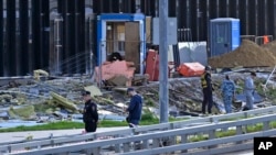 24일 러시아 수도 모스크바 시내에 무인항공기(드론) 공격이 단행된 것으로 알려진 가운데, 파손된 건물 주변 도로를 수사관들이 살피고 있다.