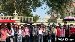 ក្រុមកូដករនៃក្រុមហ៊ុនណាហ្គាវើលដ៍ ឈរជុំគ្នាដោយលើកលិខិតដែលចុះហត្ថលេខាដោយមន្រ្តីតំណាងក្រសួងការងារ នៅពីមុខក្រសួងការងារ ក្នុងរាជធានីភ្នំពេញ នាថ្ងៃទី៦ ខែមីនា ឆ្នាំ២០២៤។ (ស៊ឹម ចាន់សំណាង/វីអូអេ)