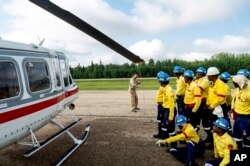 Pilot Sid Goldschmidt leads a safety briefing for South African firefighters in preparation for a helicopter transport in Fox Creek, Alberta, July 4, 2023.