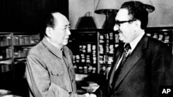 Pemimpin China Mao Zedong, kiri, berjabat tangan dengan Menteri Luar Negeri AS Henry Kissinger di Beijing, 12 November 1973. Pemerintah China menyebut Kissinger sebagai "teman lama."