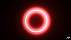 FILE - An annular solar eclipse is seen though safety glass from Siak, Riau province, Indonesia, Dec. 26, 2019. A "ring of fire" eclipse will be visible over parts of the western U.S. and Central and South America on Oct. 14, 2023.