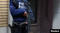 Policajac sa automatskim oružjem stražari ispred stambene zgrade, tokom policijske akcije nakon pucnjave u Briselu, Belgija, 17. oktobra 2023.