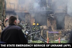 This handout photo released by the State Emergency Service of Ukraine on June 13, 2023, shows firefighters extinguishing a fire on a five-story residential building, the site of a night Russian strike, in the city of Kryvyi Rig.