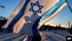 Menachem Roetter from Detroit, Michigan, walks next to an Israeli flag during the Americans March for Israel rally on the National Mall in Washington, Nov. 14, 2023.