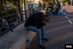 Men despair as their wives and children hide from bombs in Gaza, pictured on Oct. 13, 2023, in Ramallah, West Bank. (Yan Boechat/VOA)