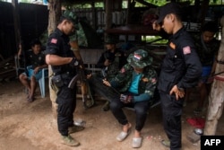 FILE - Members of the Karenni Nationalities Defense Force (KNDF) and Kareni Army (KA) are seen at a checkpoint near Demoso, in Myanmar's eastern Kayah state, Oct. 19, 2021.