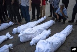 Palestinians mourn their relatives killed in the Israeli bombardment of the Gaza Strip, in front of the morgue in Deir al Balah, Nov. 1, 2023.