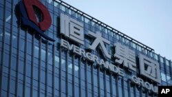 រូបឯកសារ៖ ផ្លាកយីហោ​ក្រុមហ៊ុន Evergrande Group ត្រូវបាន​ថត​ពី​អគារ​របស់​ក្រុមហ៊ុន នៅខេត្ត Guangdong ប្រទេសចិន កាលពីថ្ងៃទី២៤ ខែកញ្ញា ឆ្នាំ២០២១។ 