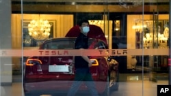 A worker walks in a Tesla showroom in Beijing, May 30, 2023.