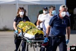 Paramedics carry an injured survivor of a shipwreck to an ambulance at the port in Kalamata town, about 240 kilometers (150miles) southwest of Athens, June 14, 2023.