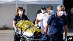 Paramedics carry an injured survivor of a shipwreck to an ambulance at the port in Kalamata town, about 240 kilometers (150miles) southwest of Athens, June 14, 2023.