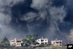 Black smoke rises from an Israeli airstrike on the outskirts of Aita al-Shaab, a Lebanese border village with Israel, as it is seen from Rmeish village in south Lebanon, Nov. 21, 2023.