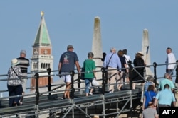 Turis berjalan menuju Lapangan Santo Markus di Venesia, 31 Juli 2023. (Foto: AFP)