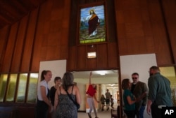 Seorang anak perempuan melompat untuk menyentuh pintu masuk tempat suci Gereja First Baptist di Mt. Vernon, Illinois, Minggu, 10 September 2023. (AP/Jessie Wardarski)