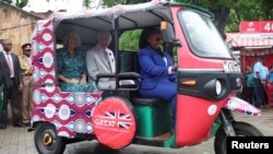 Mfalme Charles wa Uingereza na Malkia Camilla wakiwa wamepanda bajaji ya umeme Mombasa, Novemba 3, 2023. REUTERS/Phil Noble.