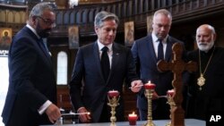 U.S. Secretary of State Antony Blinken, second from left, participates in a World Refugee Day event with British Foreign Secretary James Cleverly, left, at Ukrainian Catholic Cathedral in London, June 20, 2023. The gentlemen to Blinken's right were not identified.