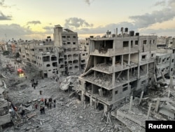 Palestinians walk at the site of Israeli strikes in Jabalia refugee camp in the northern Gaza Strip on Nov. 21, 2023.