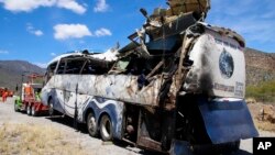 A crashed bus sits attached to a tow truck the side of the road near Villa de Tepelmeme, Oaxaca state, Mexico, Oct. 6, 2023.