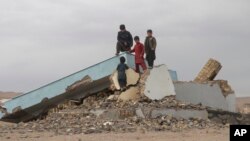 Children climb on a destroyed building in Zindan Jan, Afghanistan, Jan. 4, 2024, three months after a massive earthquake hit the area. 