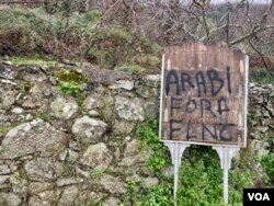 A sign in Corsica calling on Arab migrants to leave. Surveys show public perceptions towards immigrants in Europe have improved. (Lisa Bryant/VOA)