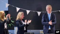 Far-right Party for Freedom leader Geert Wilders, right, celebrates with Fleur Agema, section left, and other party members after winning the most votes in a general election, in The Hague, Netherlands, Nov. 23, 2023. 