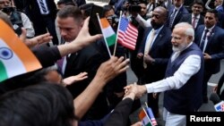 나렌드라 모디(오른쪽 가운데) 인도 총리가 20일 미국 뉴욕 시내 롯데 호텔에 도착해 환영객의 손을 잡고 있다. 