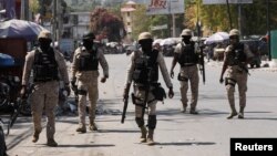 FILE - Police patrol a street after authorities extended the state of emergency amid gang violence that has threatened to bring down the government, forcing thousands to flee their homes, in Port-au-Prince, Haiti, March 8, 2024. 