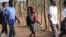 FILE - Esther Bote, 14, walks to school with her friends on the periphery of Save Valley Conservancy, Zimbabwe, on July 10, 2024.
