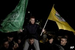 A Palestinian man is carried on shoulders after being released from prison by Israel, in the West Bank town of Ramallah, Dec.1, 2023.